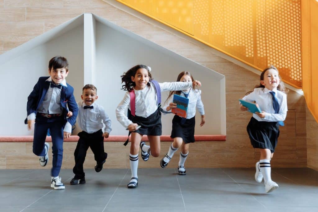 Children running into school classroom